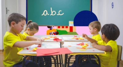 Crianças participam de atividade de colagem em sala de aula, com ambiente educativo e lúdico voltado à educação infantil.