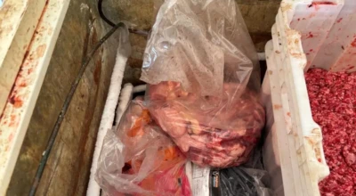 Carne é armazenada em ambiente sujo e sem higiene, com risco de contaminação e violação das normas sanitárias.