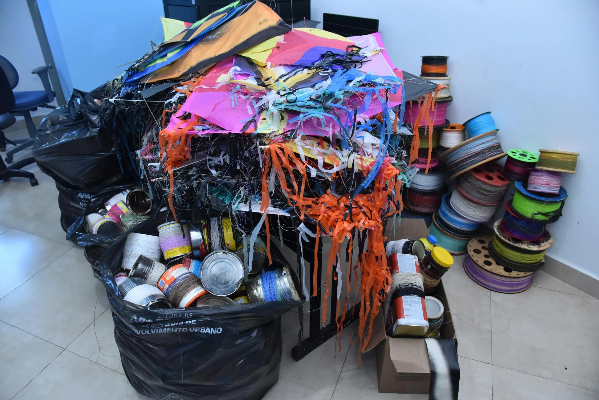 A imagem mostra pipas, carretéis e linhas cortantes apreendidos durante a operação contra o uso de cerol.