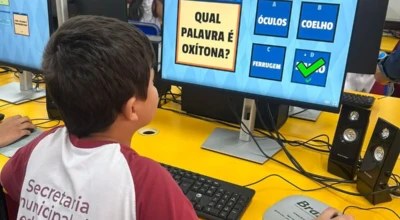 Aluno da rede municipal utiliza computador em atividade escolar de português.