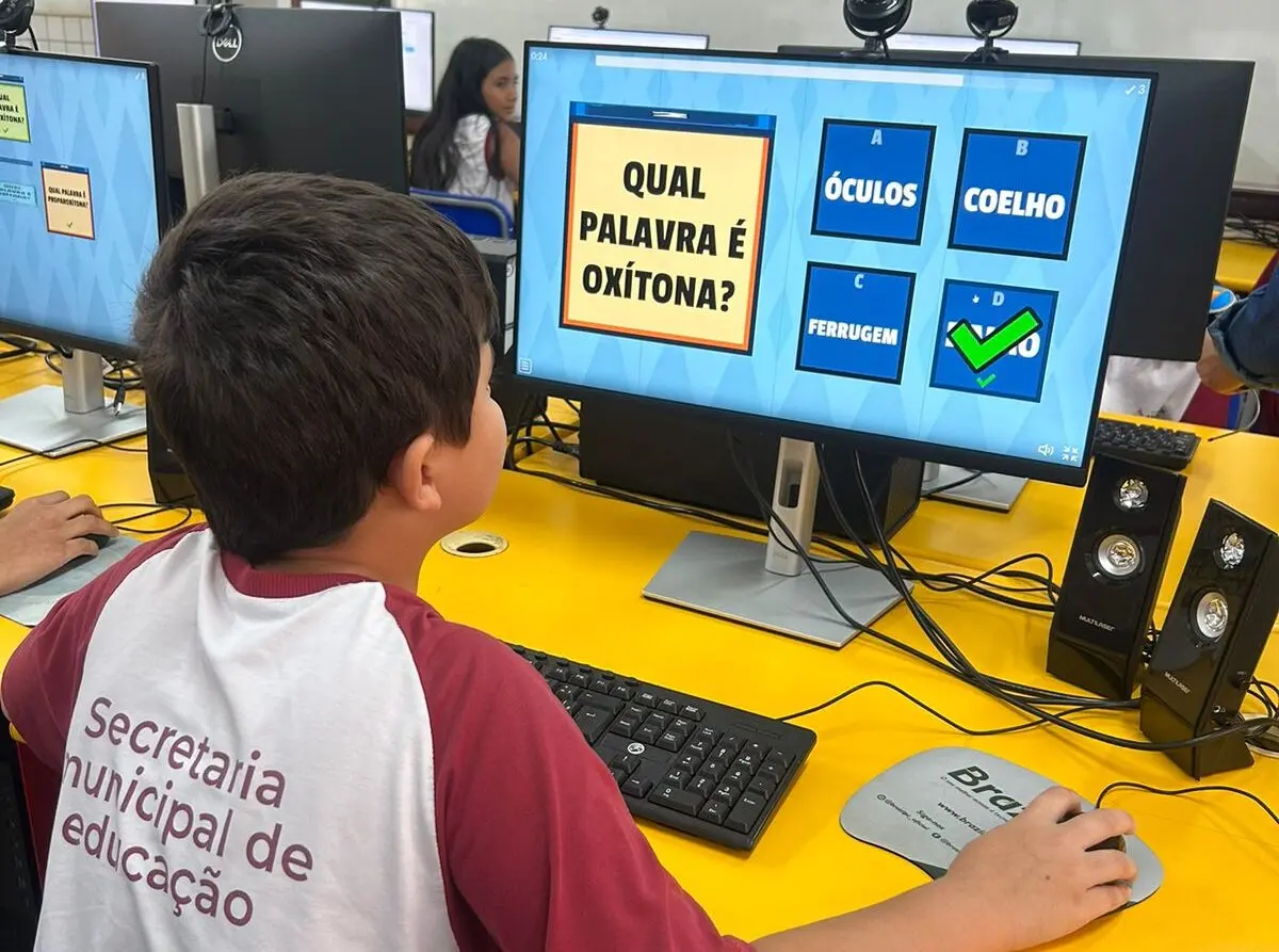 Aluno da rede municipal utiliza computador em atividade escolar de português.