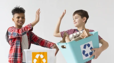 Crianças segurando uma caixa com o símbolo da reciclagem.