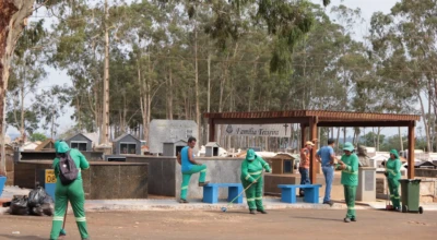 Equipe de limpeza varre e organiza um cemitério.