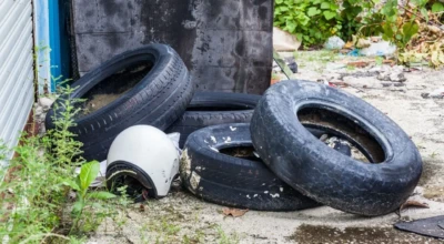 Foto de pneus abandonados em terreno.