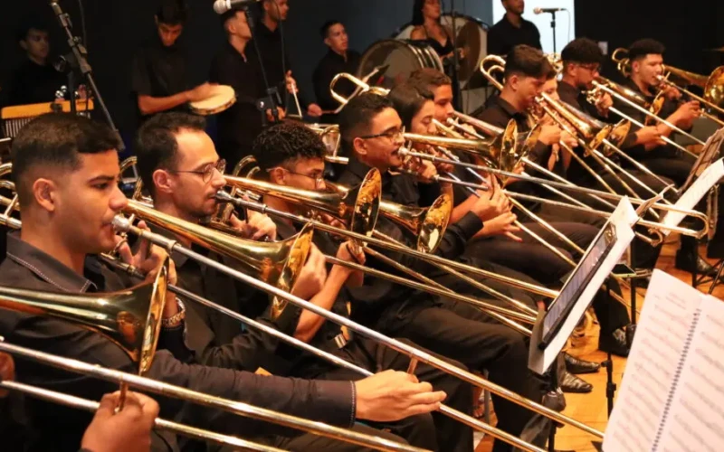 Músicos da banda sinfônica tocam trombones em apresentação