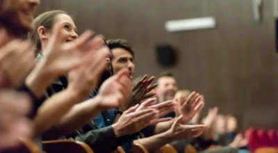Plateia aplaudindo apresentação.