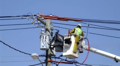 Funcionários de companhia elétrica fazendo manutenção nos fios de energia.