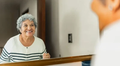 Foto de uma mulher se olhando no espelho.