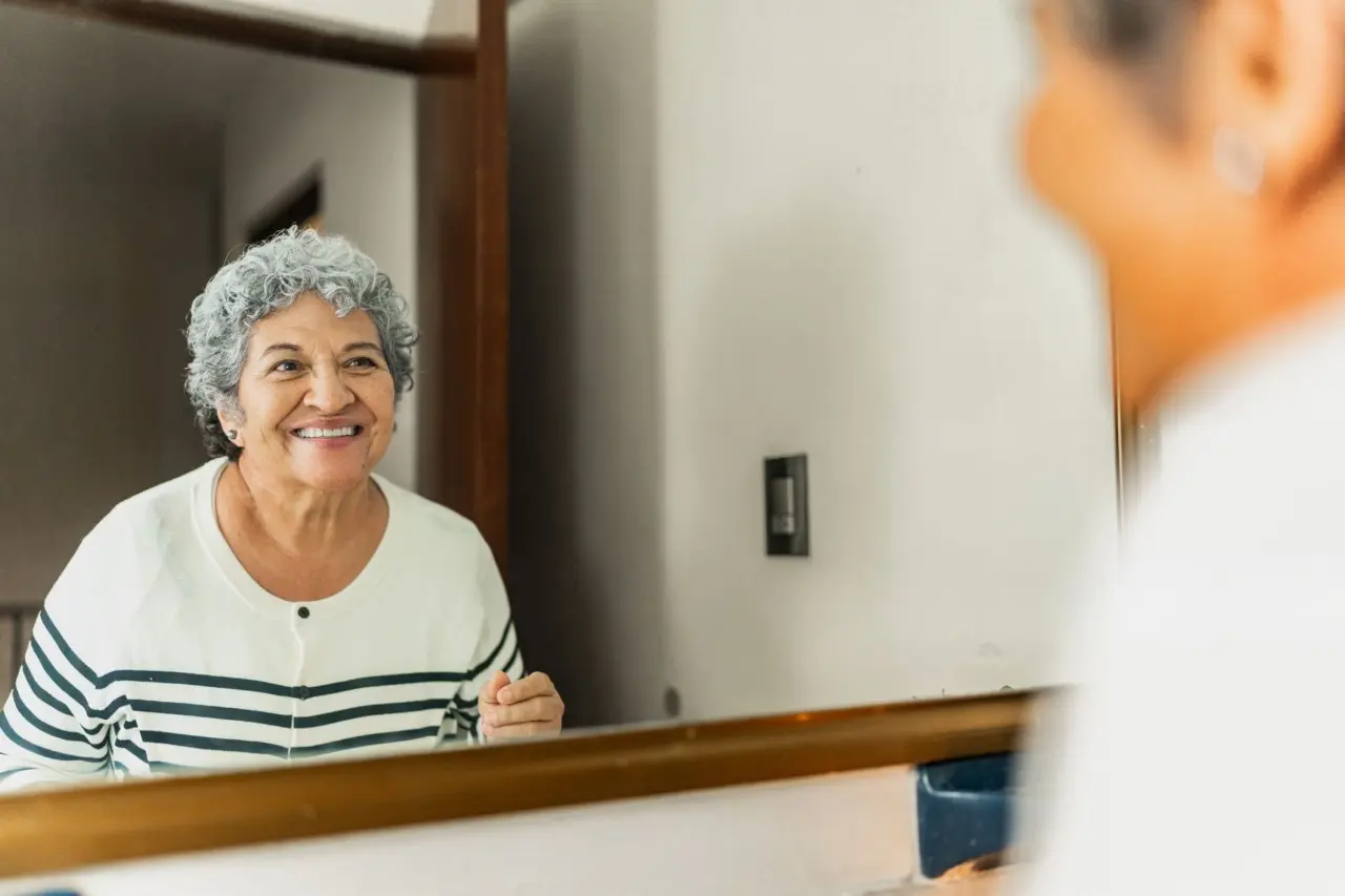 Foto de uma mulher se olhando no espelho.
