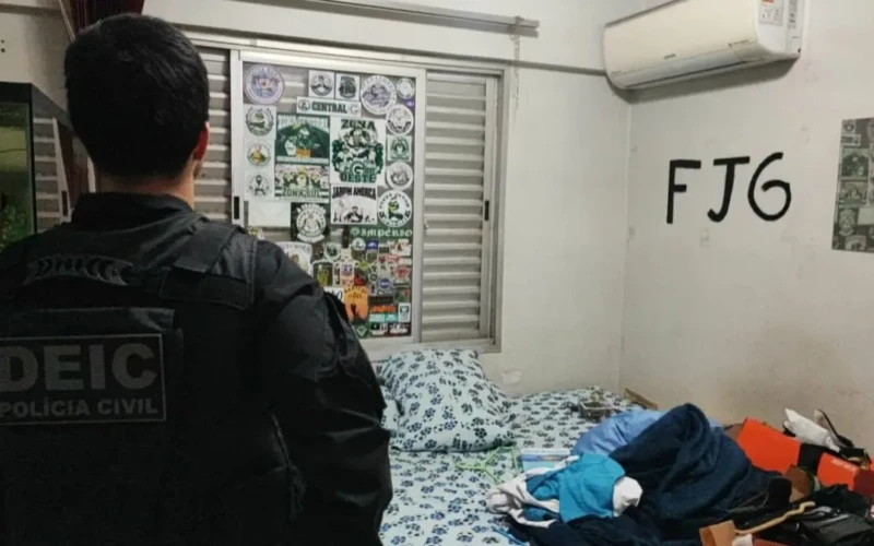 Agente da PCGO no local onde foi apreendido materiais de torcida organizada.