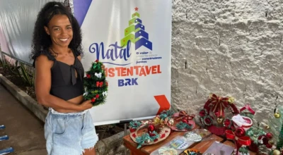 Participante do projeto natal sustentável ao lado dos itens produzidos com reciclagem.