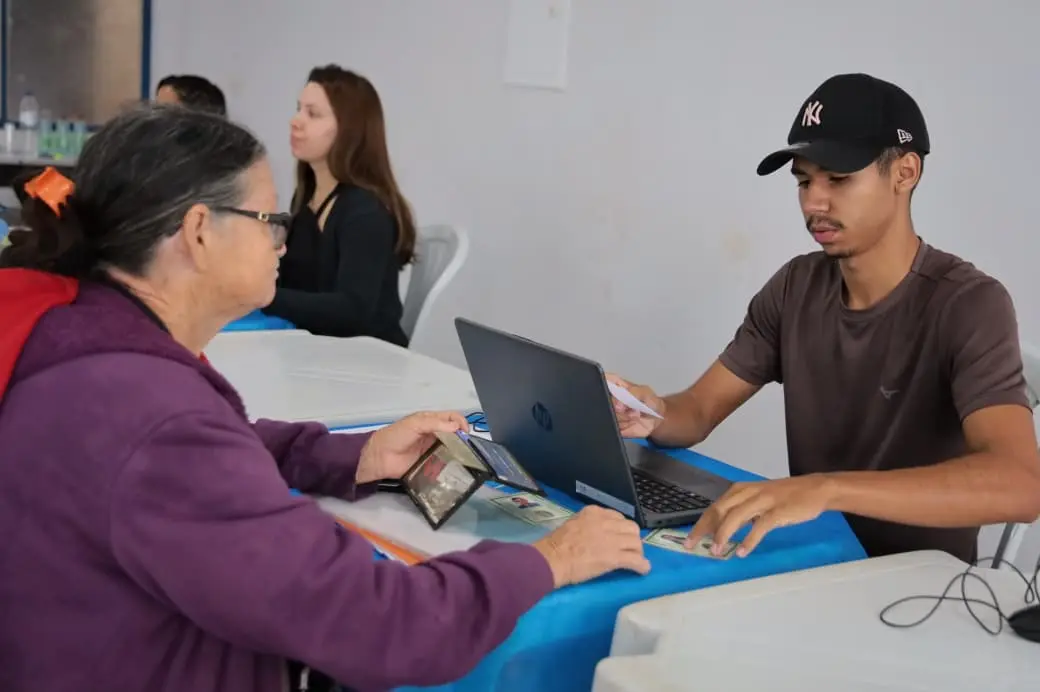 Funcionário atendendo mulher que participa do programa.