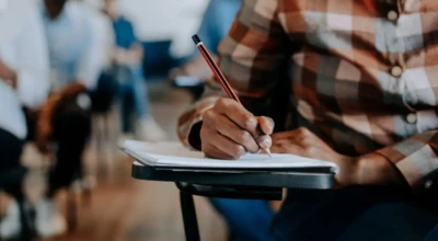 Candidato sentado em cadeira realizando uma prova.