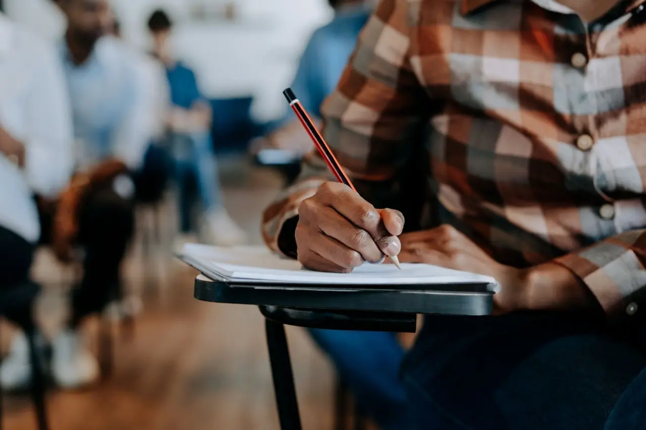 Candidato sentado em cadeira realizando uma prova.