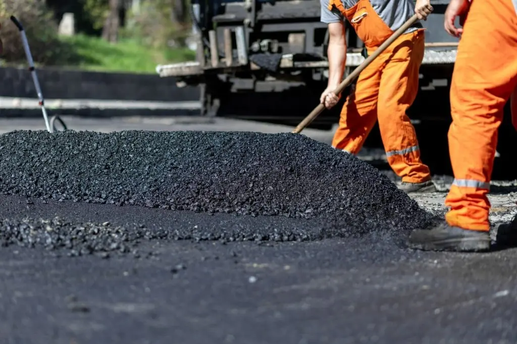 Homens trabalhando na construção do asfalto.