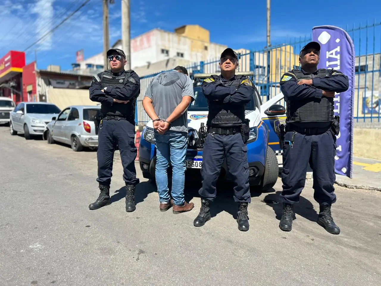 Equipe da GCM com suspeito algemado.