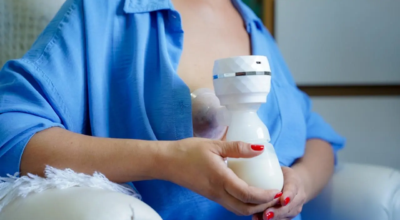 Mulher com uma bombinha de sucção coletando leite materno