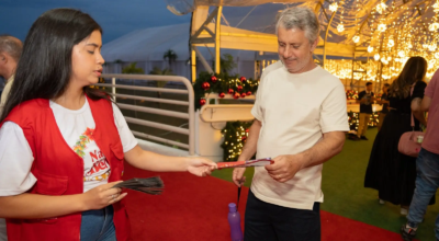 Funcionária entregando panfleto no Natal do Bem